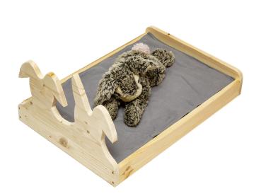 Kaninchenbett mit grauer Decke in natur